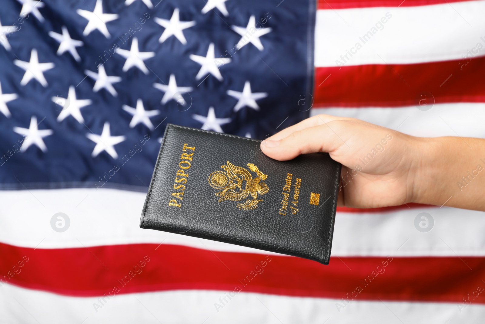 Photo of Woman holding passport against flag of USA, closeup