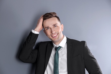 Portrait of young man with beautiful hair on grey background