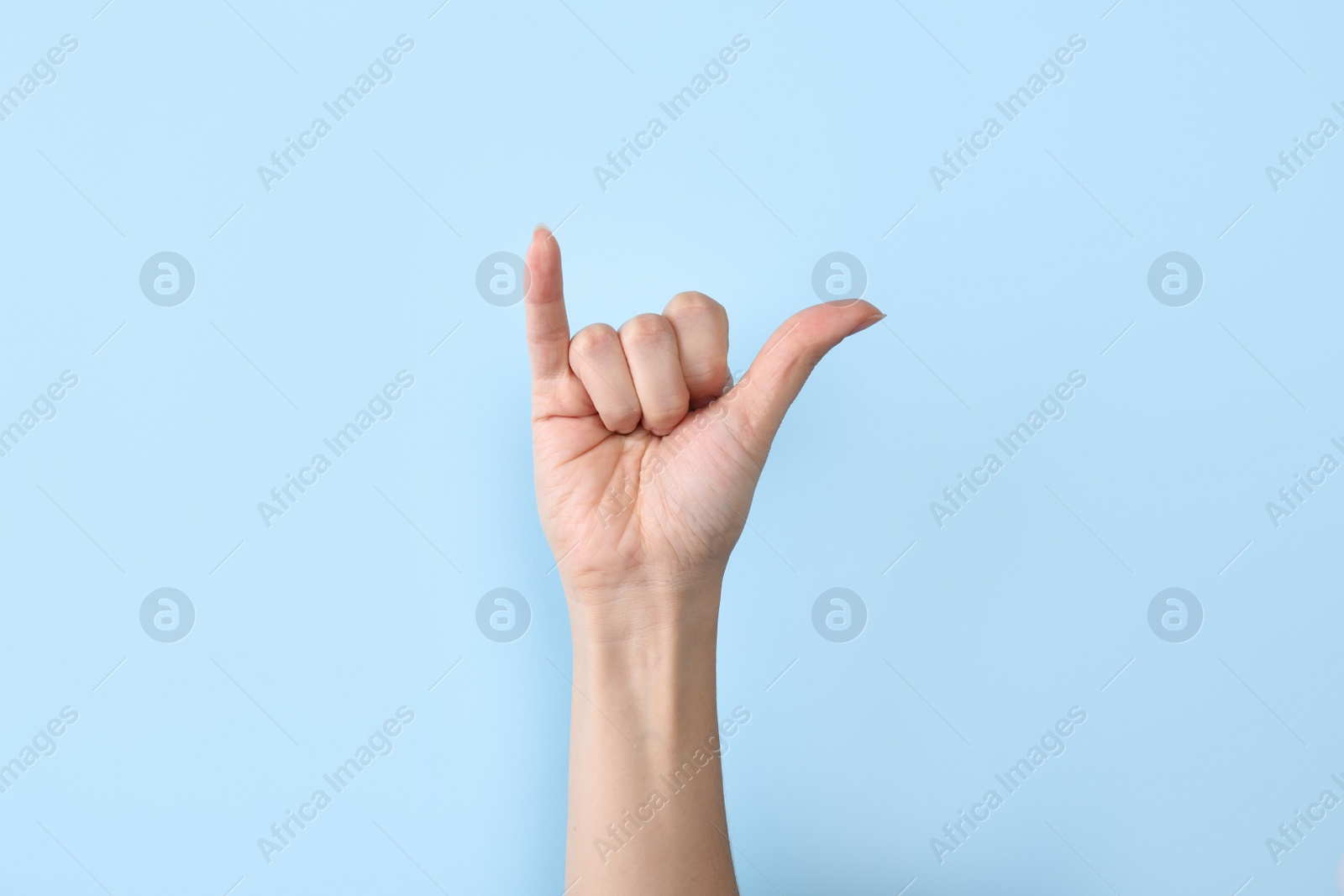 Photo of Woman showing Y letter on color background, closeup. Sign language