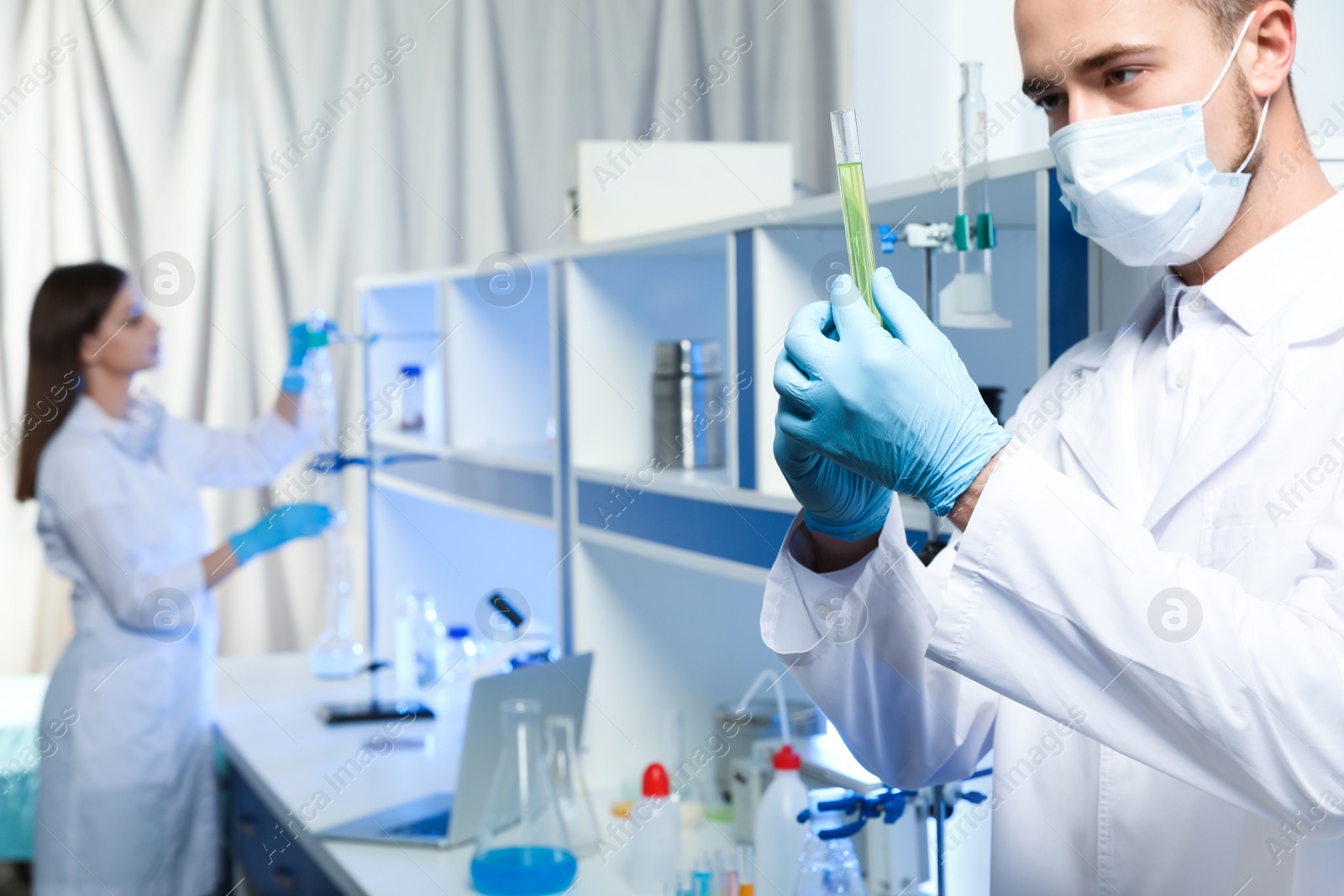 Photo of Scientist holding test tube with liquid indoors, closeup. Laboratory analysis