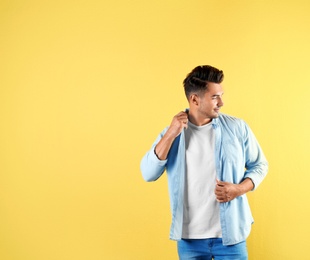 Photo of Young man in stylish jeans on color background with space for text