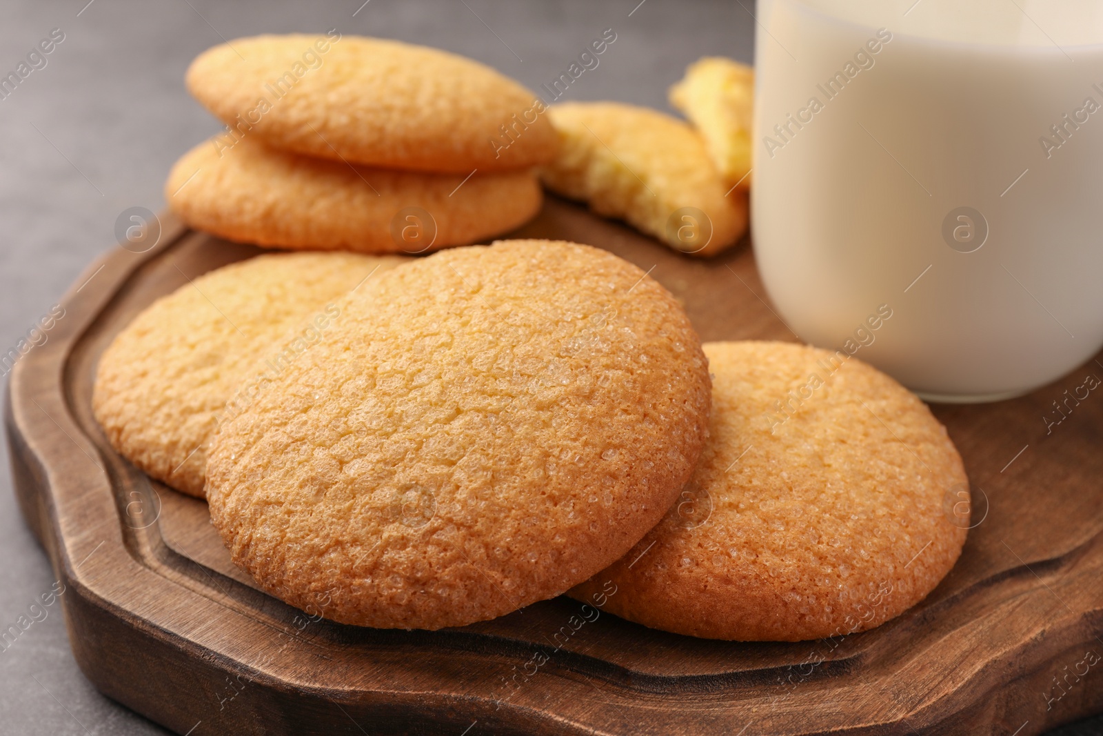 Photo of Delicious Danish butter cookies and milk on wooden board, closeup