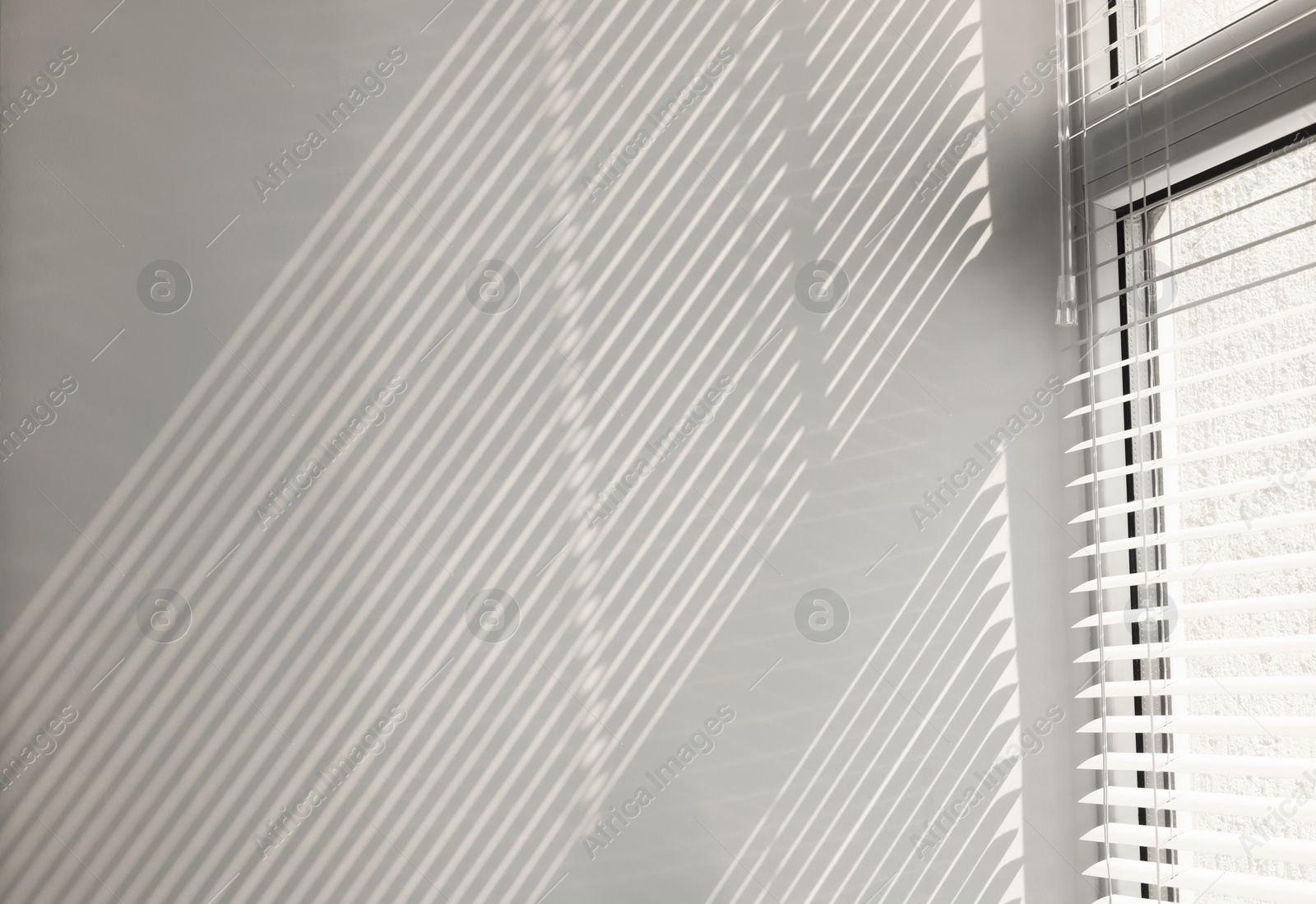 Photo of Shadow from window and blinds on beige wall indoors