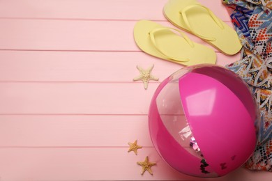 Photo of Flat lay composition with beach ball on pink wooden background. Space for text