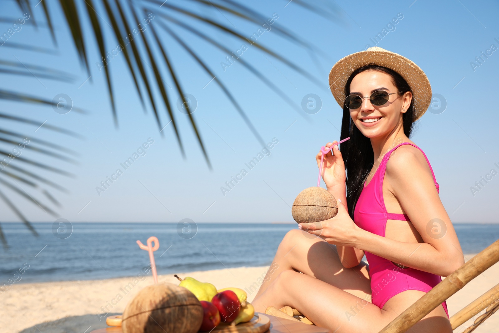 Photo of Beautiful woman with tropical cocktail on sunny beach