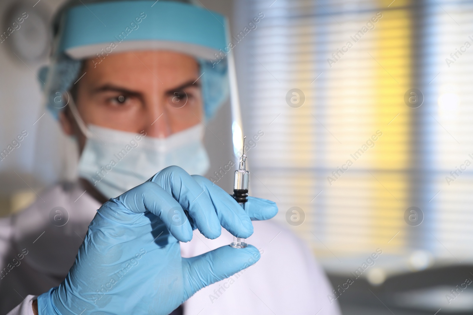 Photo of Doctor holding syringe with vaccine against Covid-19 in laboratory, focus on hand