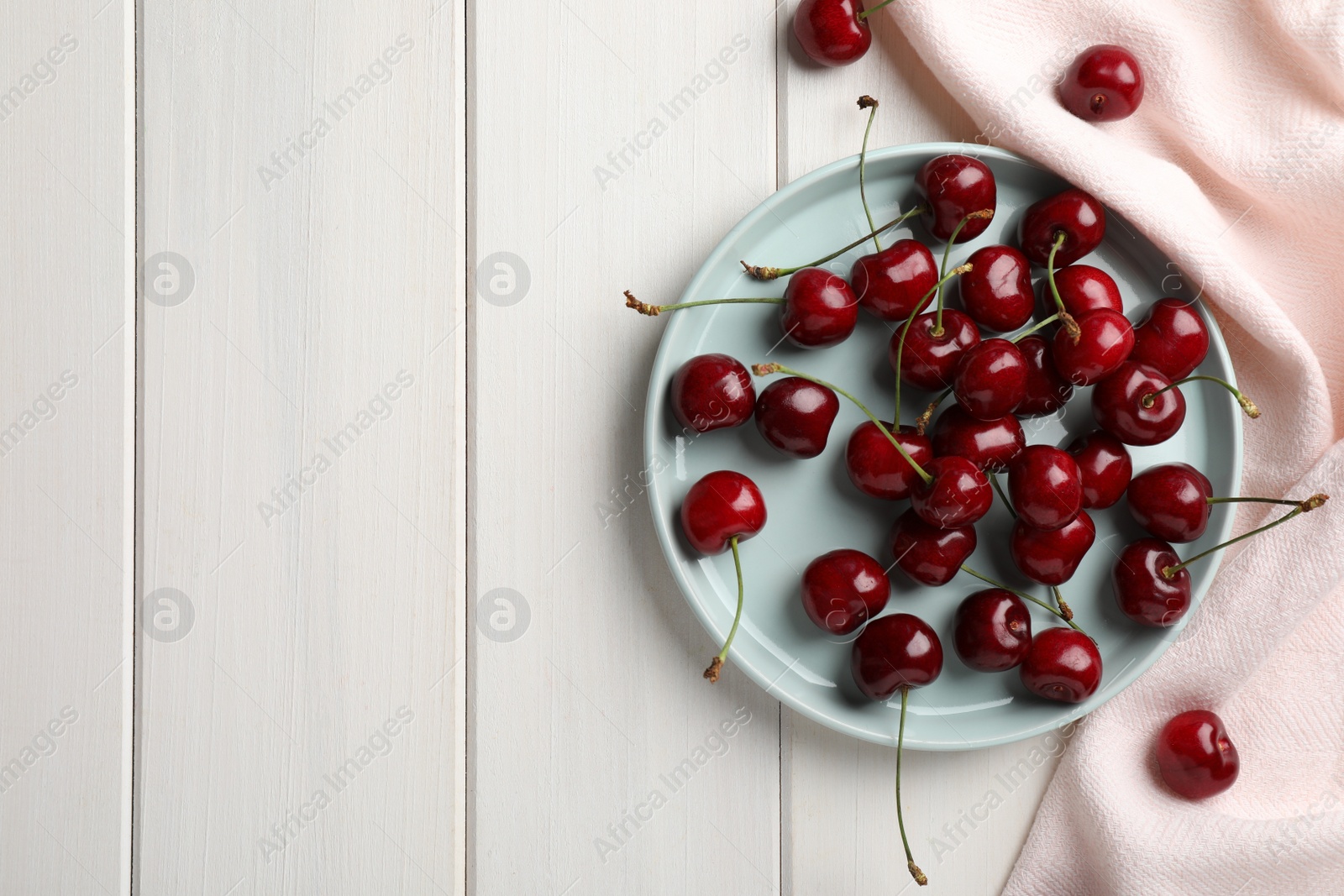 Photo of Sweet red cherries on white wooden table, flat lay. Space for text