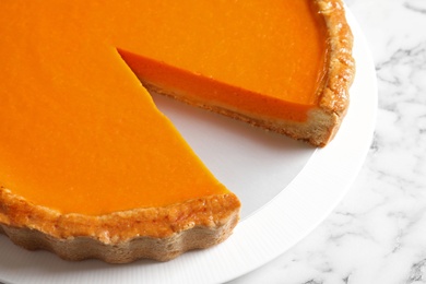 Plate with fresh delicious homemade pumpkin pie on marble table