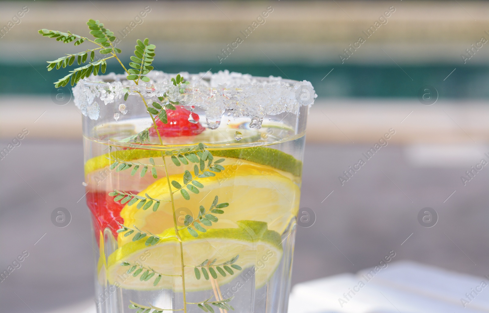 Photo of Delicious refreshing lemonade with raspberries outdoors, closeup. Space for text