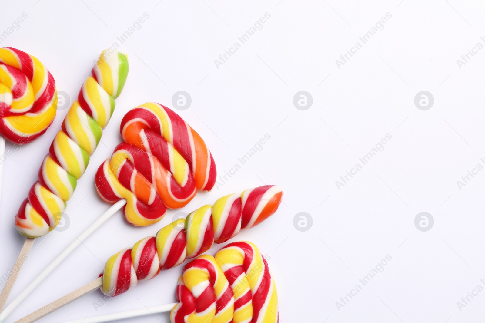 Photo of Sweet lollipops on light background, flat lay. Space for text