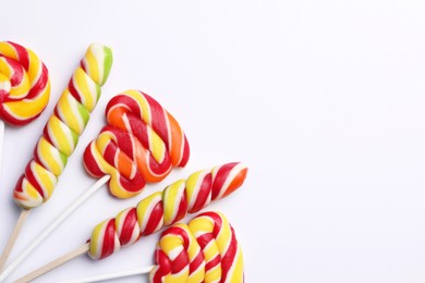 Sweet lollipops on light background, flat lay. Space for text