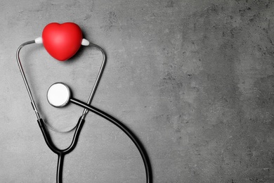 Photo of Stethoscope and red heart with space for text on grey background, top view