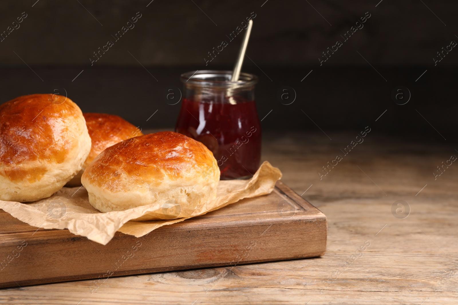 Photo of Tasty scones prepared on soda water and jam on wooden table, space for text