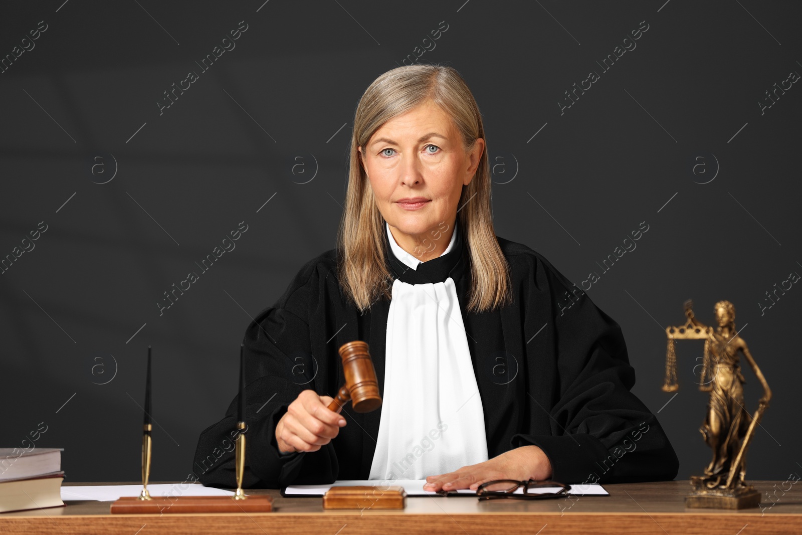 Photo of Judge striking mallet at wooden table indoors