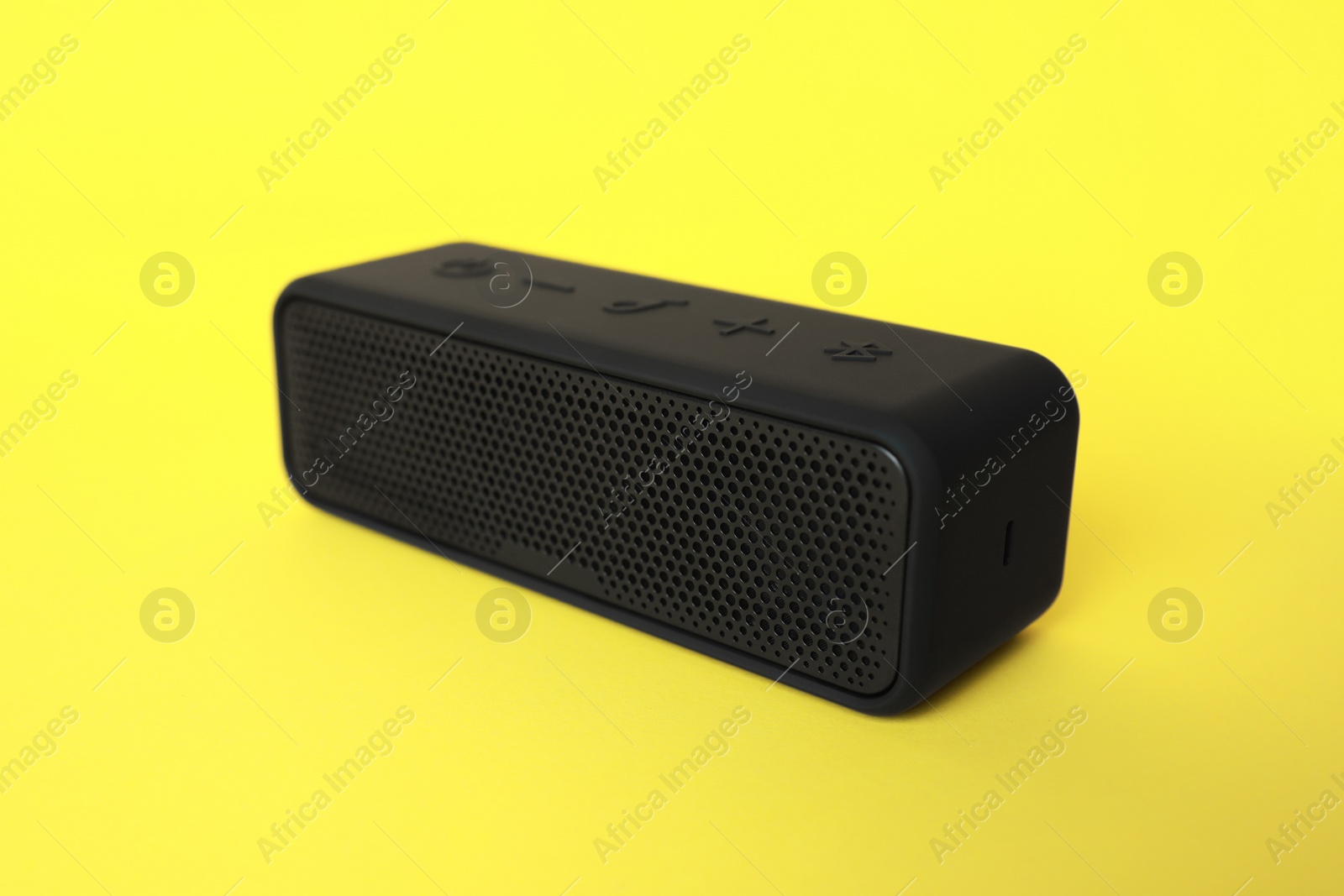 Photo of One portable bluetooth speaker on yellow background. Audio equipment