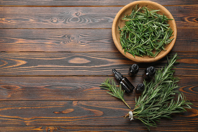 Flat lay composition with fresh rosemary on wooden table. Space for text