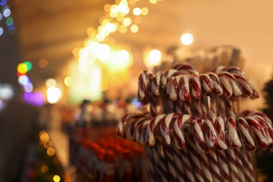 Photo of Candy canes on Christmas fair stall display, closeup. Space for text