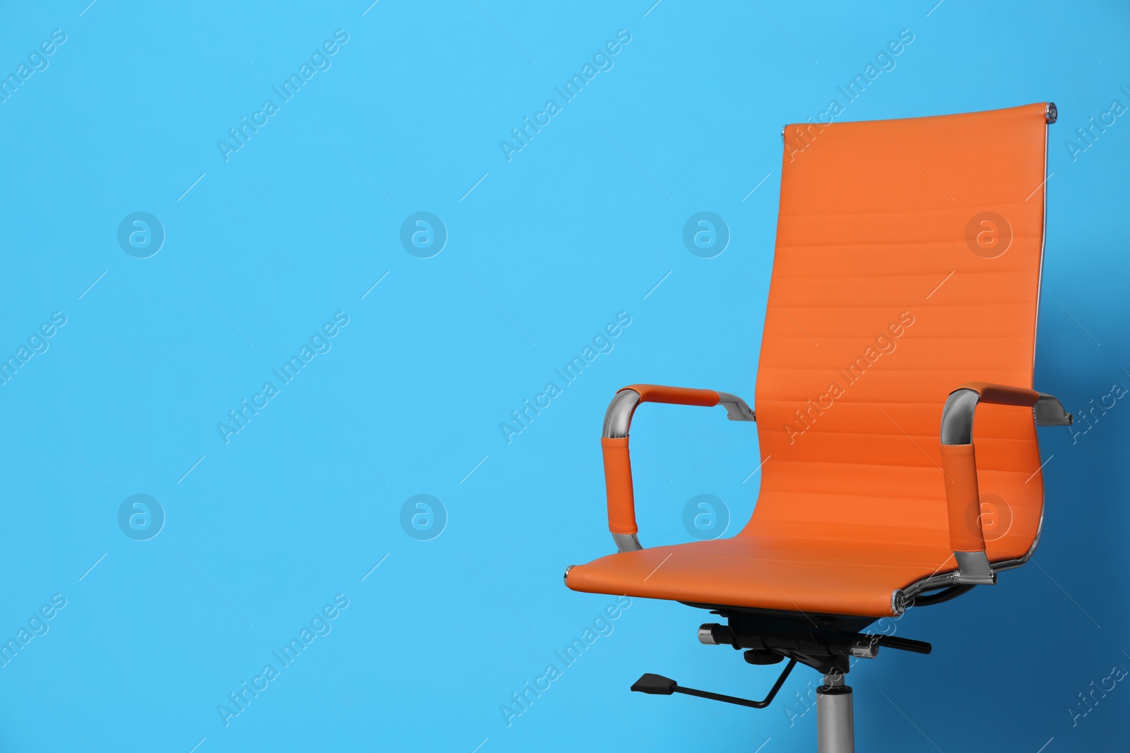 Photo of Comfortable office chair on light blue background, space for text