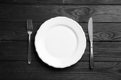 Elegant table setting on black wooden background, flat lay