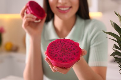 Woman with fresh pitahaya indoors, closeup. Exotic fruit