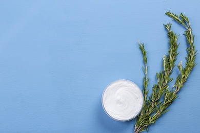 Photo of Jar with body care cream and rosemary on color background