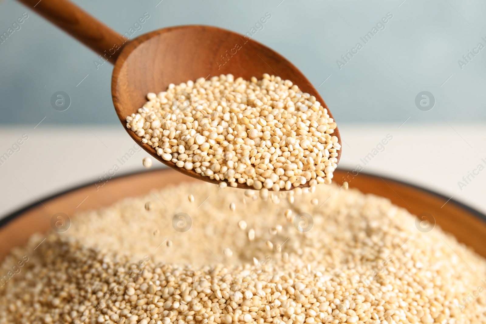 Photo of Spoon and bowl with white quinoa, closeup