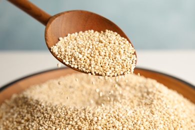 Photo of Spoon and bowl with white quinoa, closeup