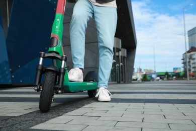 Photo of Man with modern electric kick scooter on city street, closeup. Space for text