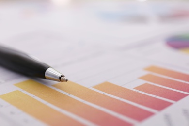 Pen on paper document with chart, closeup and space for text. Investment analysis