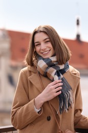 Beautiful woman in warm scarf on city street
