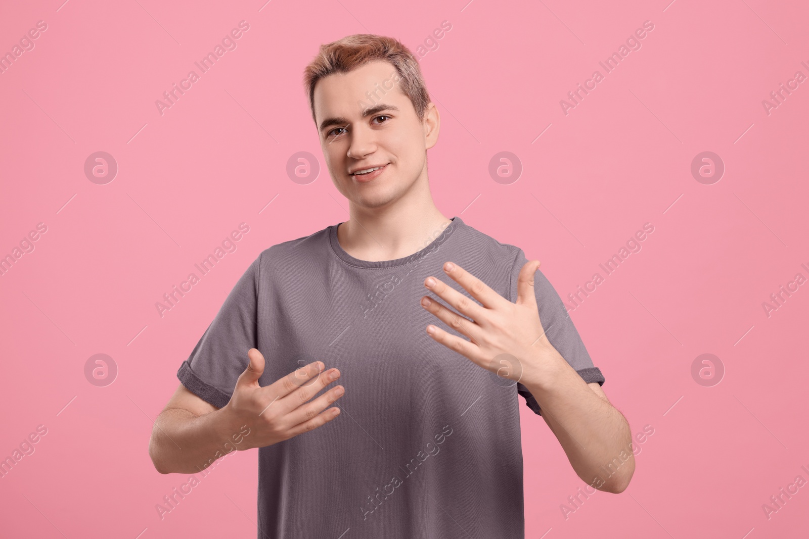 Photo of Happy man inviting to come in against pink background