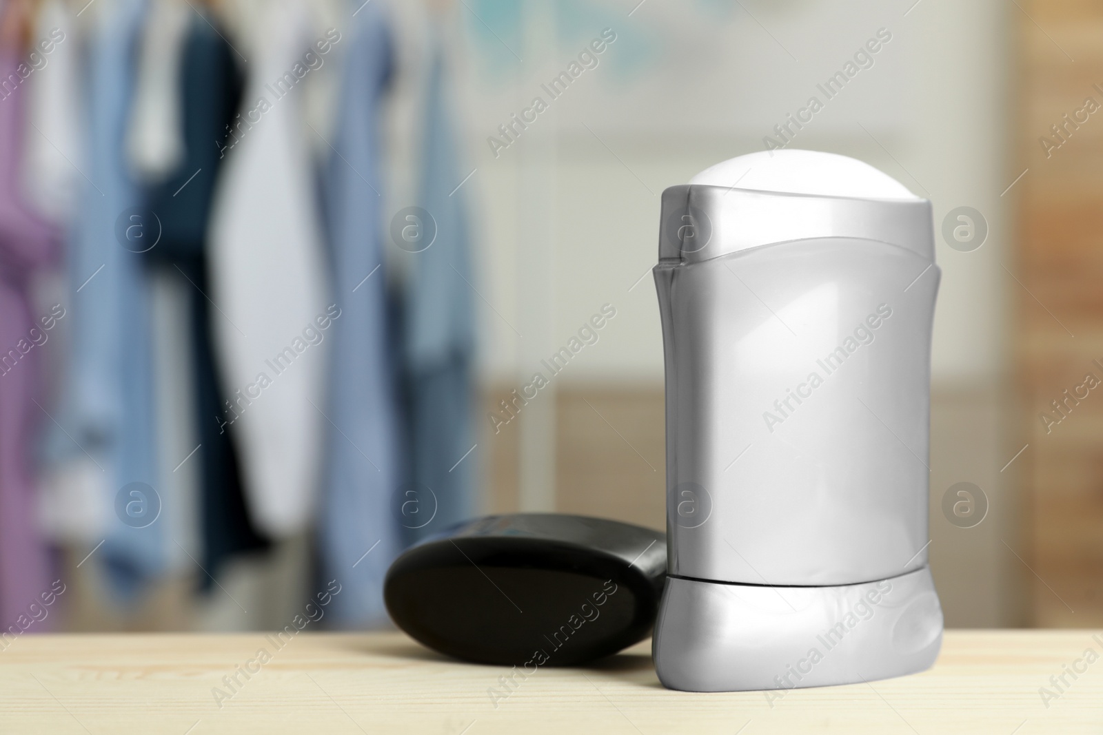 Photo of Stick deodorant on table against blurred background. Space for design