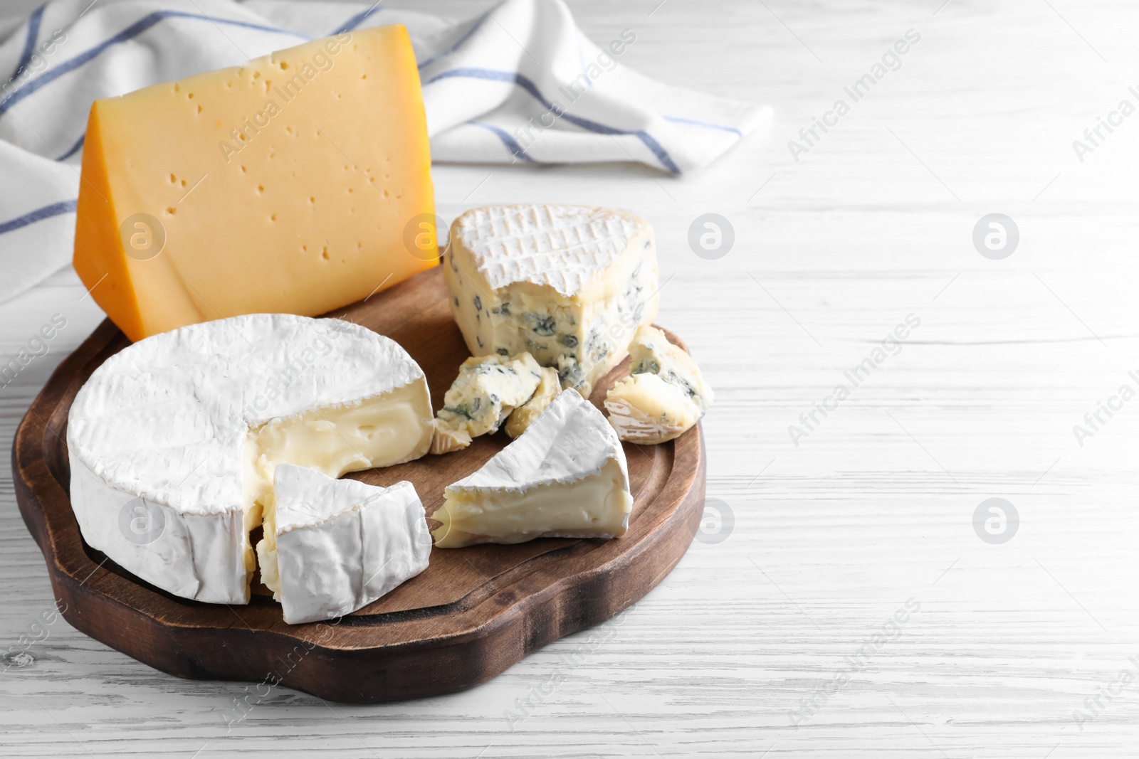 Photo of Fresh dairy products on white wooden table, space for text