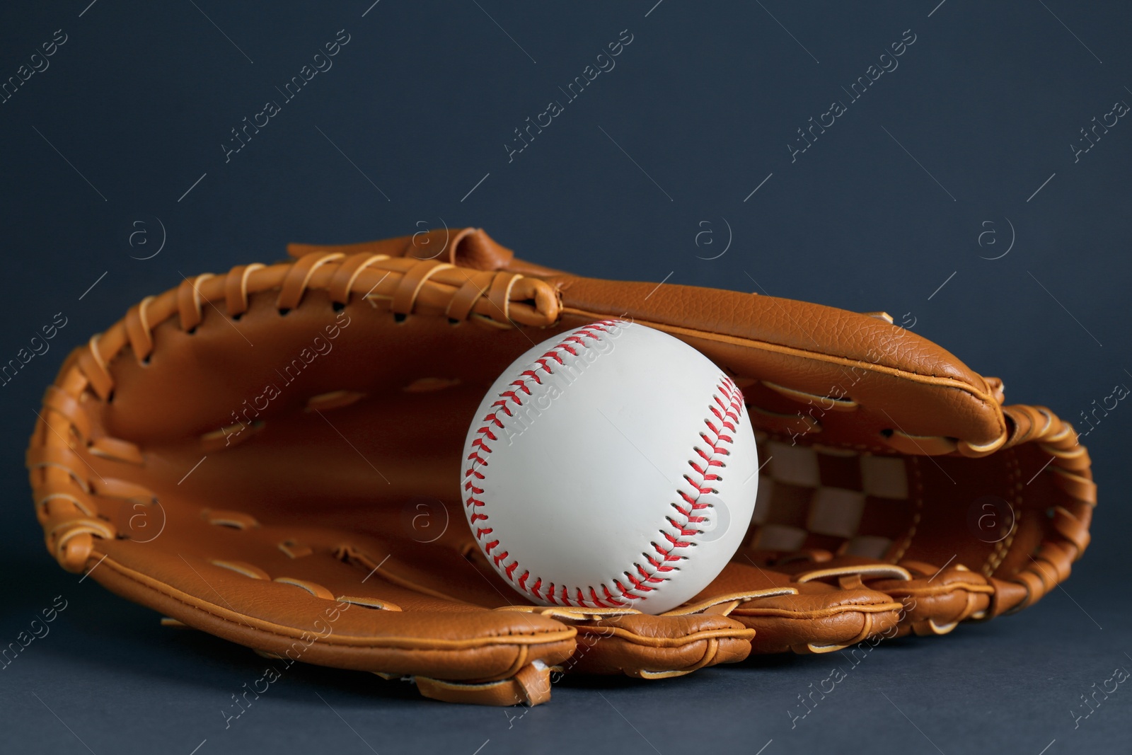 Photo of Catcher's mitt and baseball ball on dark background. Sports game