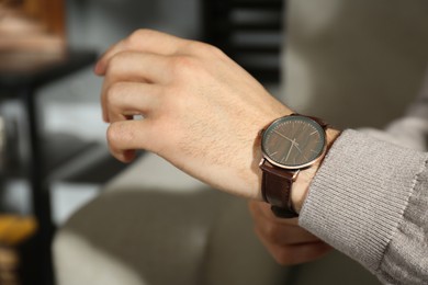 Photo of Man with luxury wrist watch indoors, closeup