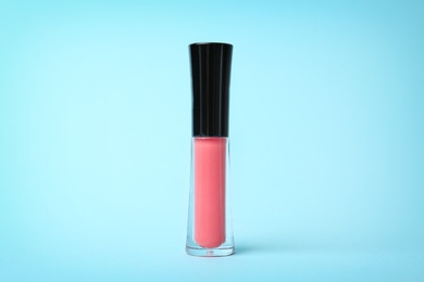 Photo of Beautiful lip gloss on color background