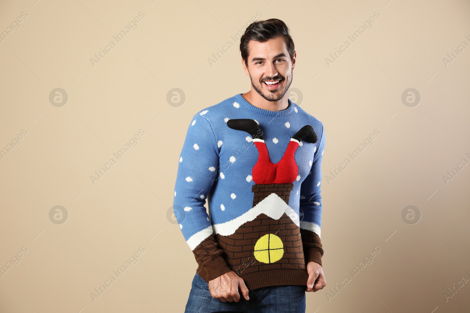 Photo of Portrait of happy man in Christmas sweater on beige background