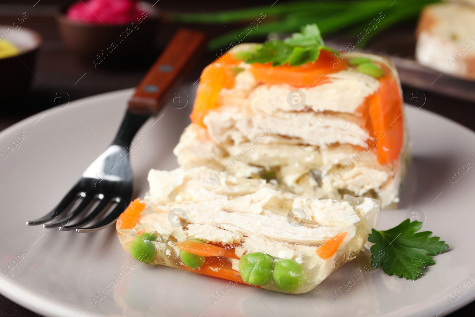 Photo of Delicious chicken aspic with vegetables on plate, closeup