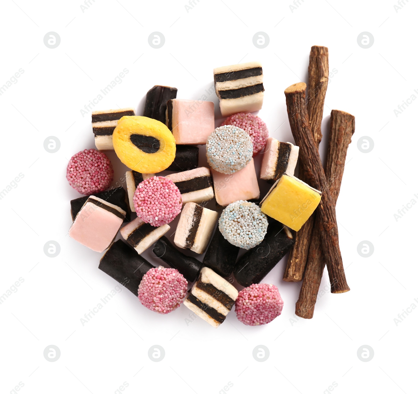 Photo of Tasty candies and dried cut liquorice root isolated on white, top view