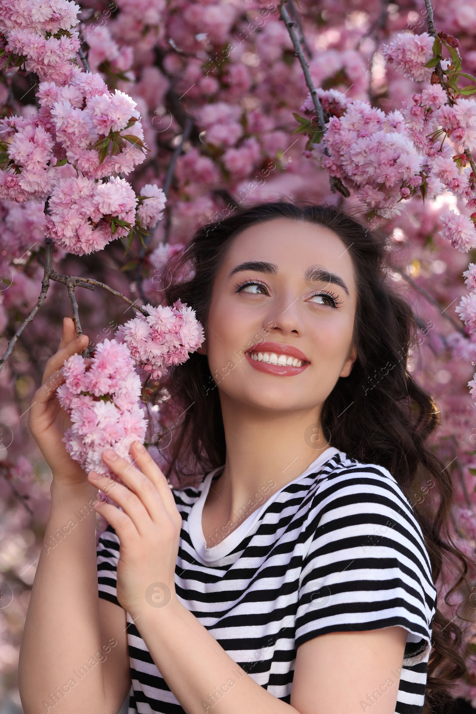 Photo of Beautiful woman near blossoming sakura tree on spring day