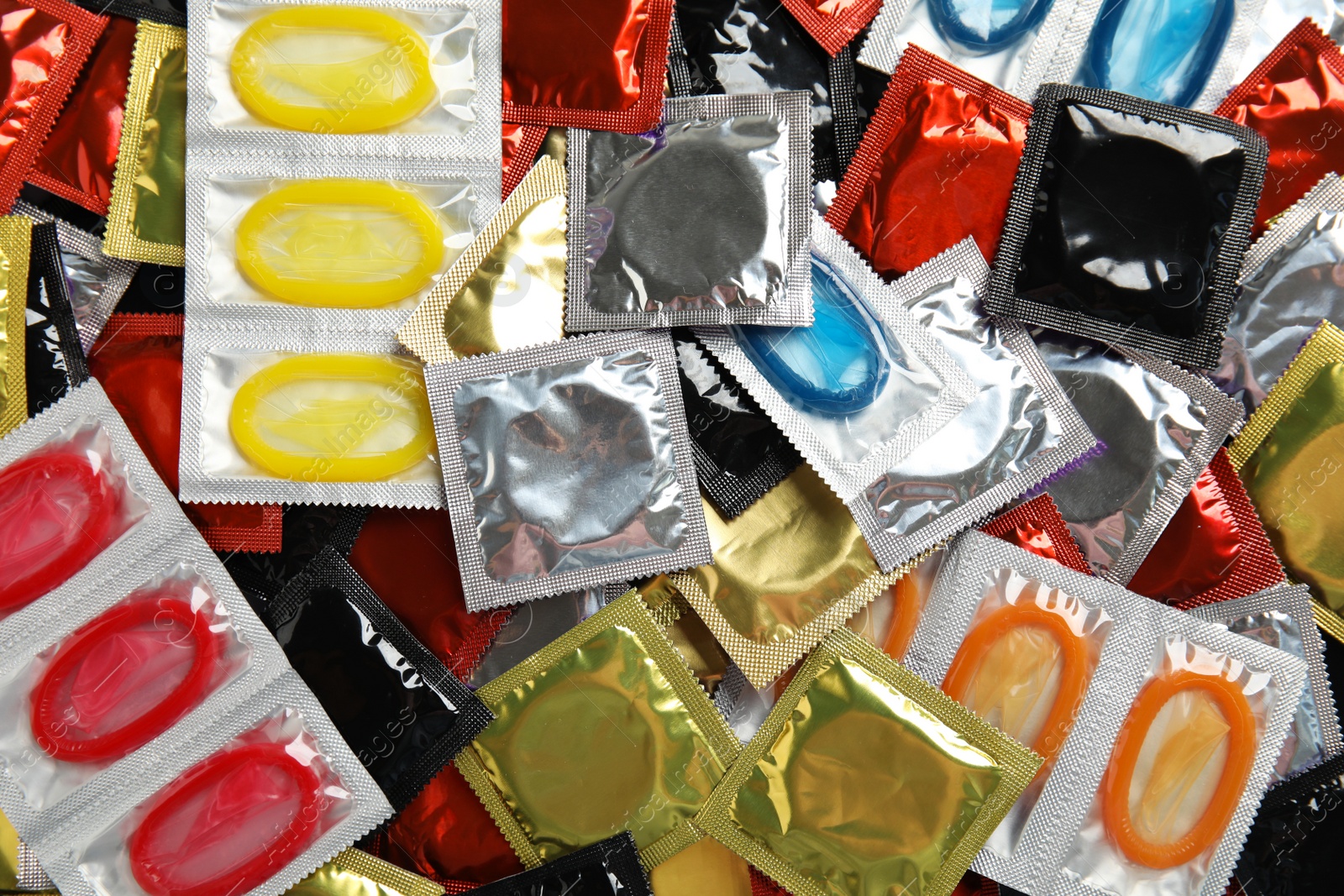 Photo of Pile of different condoms as background, top view