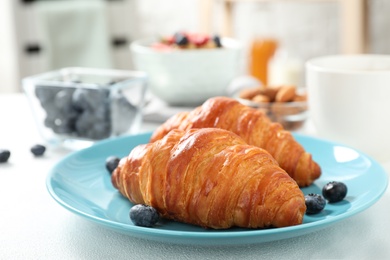 Delicious breakfast with croissants and berries on white table