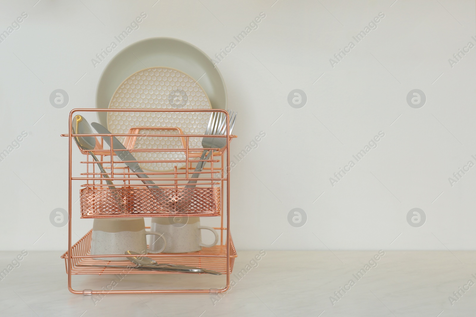 Photo of Drying rack with clean dishware on countertop in kitchen. Space for text