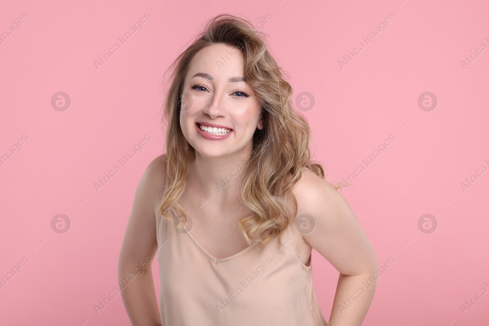 Photo of Portrait of smiling woman on pink background