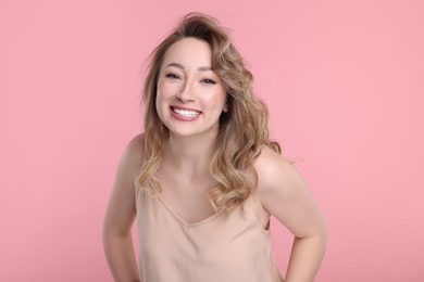 Portrait of smiling woman on pink background