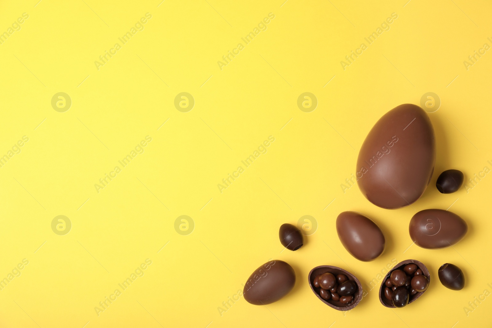 Photo of Flat lay composition with chocolate Easter eggs and space for text on color background