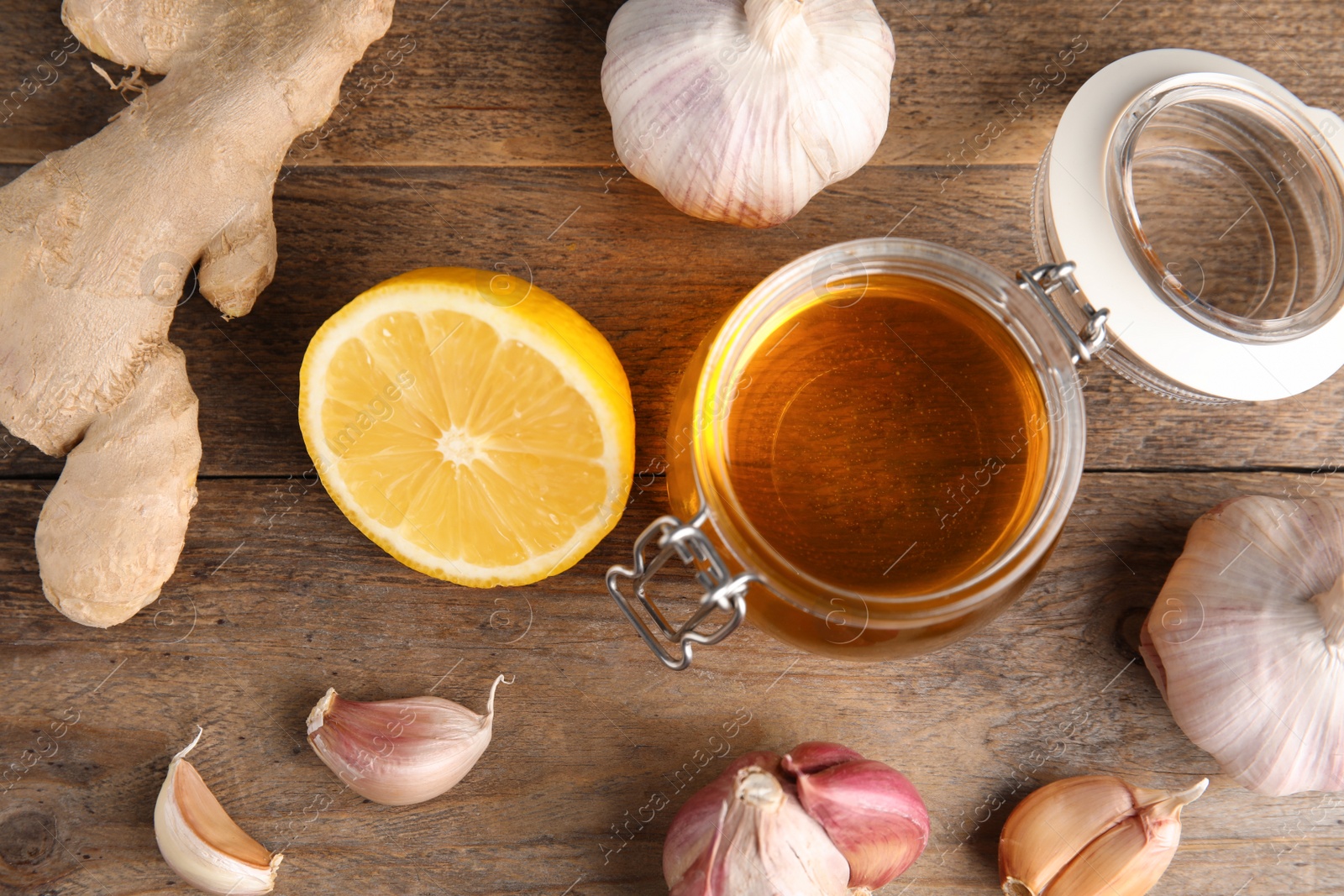 Photo of Flat lay composition with garlic and other cold remedies on wooden table