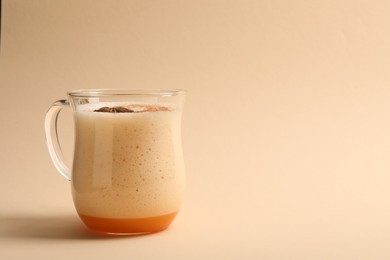 Photo of Delicious eggnog with anise on beige background. Space for text