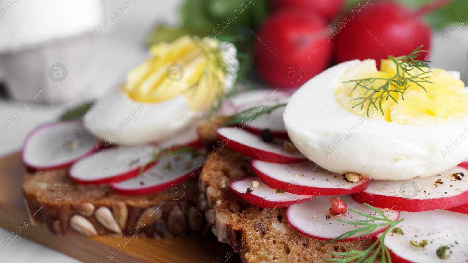 Photo of Tasty sandwiches with boiled egg and radish on table, closeup