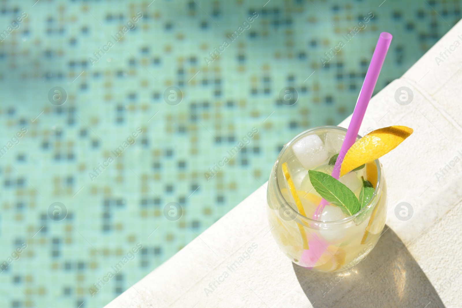 Photo of Refreshing drink with citrus slices and mint near swimming pool, above view. Space for text